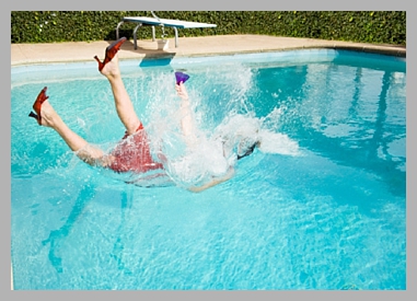 Woman falling into pool holding a drink